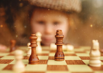 a girl looking at a chessboard and the pieces on it on an autumn day