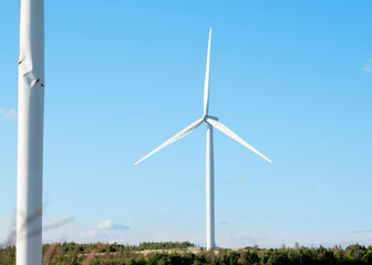 Fototapeta premium wind turbine in the field against blue sky on sunny day