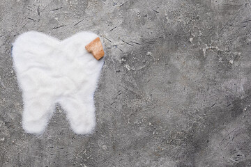 Molar tooth made of sugar on grunge background