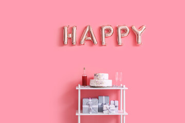 Naklejka premium Shelf with cake and air balloons hanging on color wall