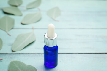 Bottle of eucalyptus essential oil on color wooden background