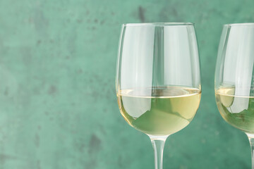 Glass of white wine on color background, closeup