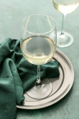 Glass of white wine on color background