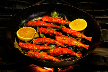 kerala style masala marinated fish fry, sardine fish in a frying pan.