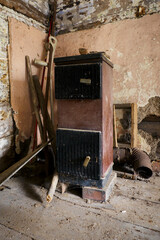 Old fuel boiler in the interior of a crumbling house (wooden house).