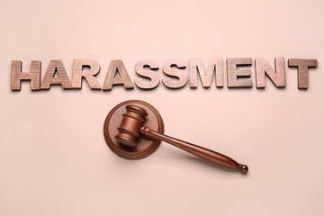 Word HARASSMENT and judge's gavel on color background