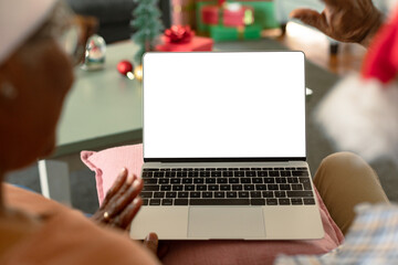 Back view of african american couple using laptop with copy space at christmas time