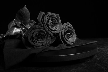 Wooden board with beautiful roses on dark background