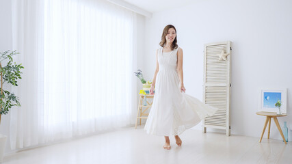 Fototapeta premium 白いワンピースを着た若い女性
