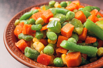 Bowl with different frozen vegetables, closeup