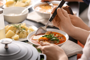 Woman eating delicious borscht with sour cream, closeup