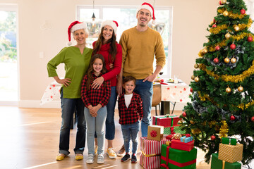 Happy multi generation caucasian family taking photo with christmas tree