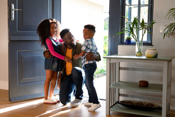 Happy african american children welcoming their father coming back home - Powered by Adobe
