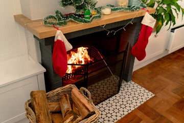 Logs of wood in basket lying at fireplace wit christmas sock