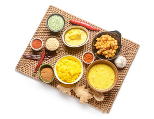 Wicker mat with traditional Indian food and spices on white background