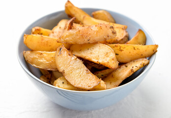 Bowl with tasty baked potato on light background