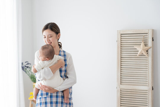 赤ちゃんを抱っこするベビーシッター（育児・子育て）