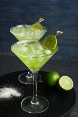 Glasses with tasty daiquiri cocktail on color wooden background, closeup