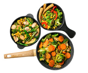 Frying pans with different vegetables on white background