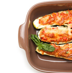 Baking dish with meat stuffed zucchini boats on white background, closeup