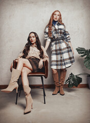Retro fashion: two beautiful young women indoors. Vintage portrait of gorgeous girls in seventies style