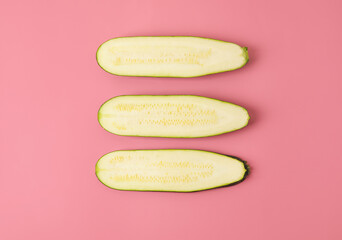 Slices of fresh zucchini squash on color background