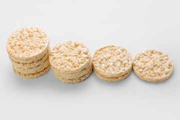 Stacks of crispy rice crackers on white background