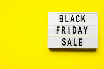 Board with text BLACK FRIDAY SALE on color background