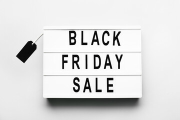 Board with text BLACK FRIDAY SALE on light background