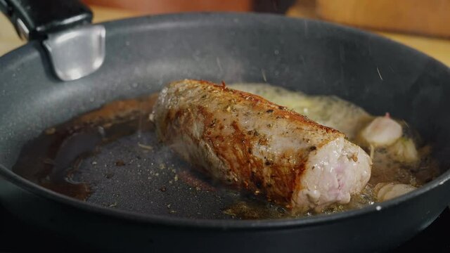 Seasoning with Falling Herbs on Fresh Fried Pork Meat. Best Slow Motion Shot Professional Cooking. Spectacular images from kitchen.