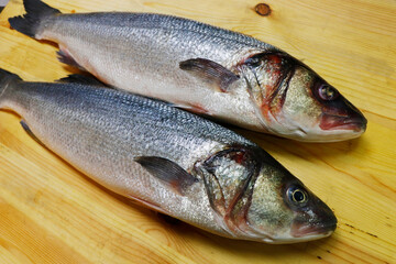 fresh atlantic sea bass on a wooden board to make fillet
