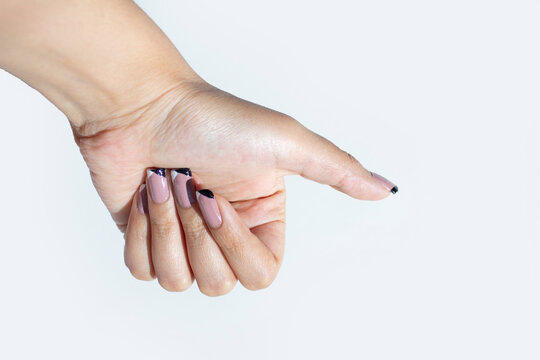 MANO DE MUJER FEMENINA EN POSICI&Oacute;N DE AGARRAR UN OBJETO, U&Ntilde;AS CON MANICURE ROSA CON BLANCO Y NEGRO