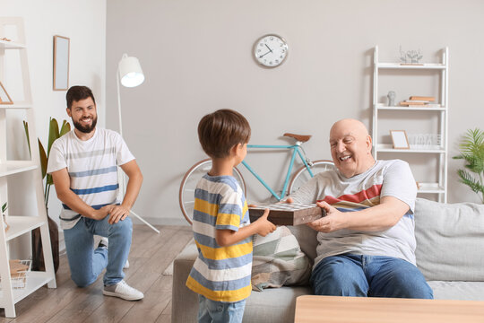 Man, His Little Son And Father Playing Chess At Home