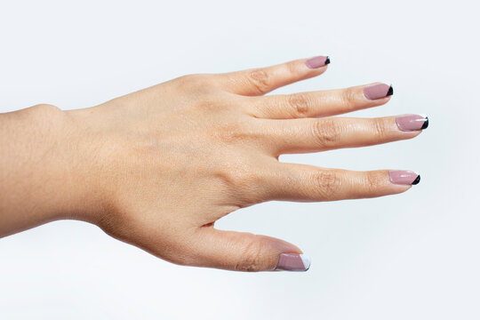 MANO FEMENINA DE MUJER CON DEDOS EXTENDIDOS Y  MANICURE SOBRE FONDO BLANCO