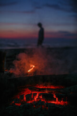 Bonfire by the sea against the background of sunset.