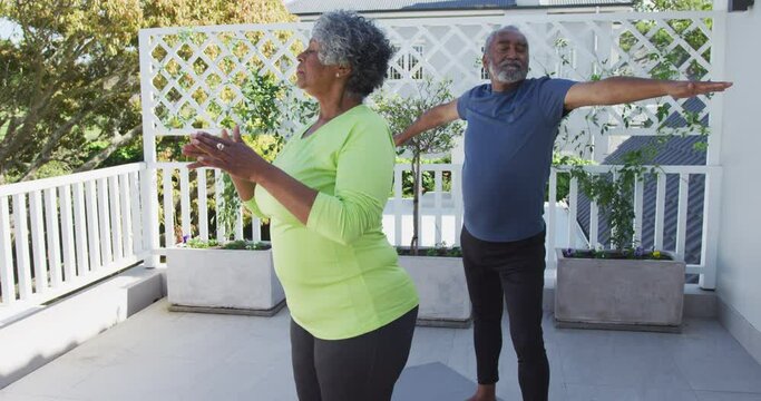 Animation of relaxed african american senior couple practicing yoga on patio