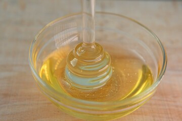 Honey. Liquid honey in transparent glass jar with dipper.Glass stick for honey in a glass cup on a wooden table. Organic Fresh honey. 