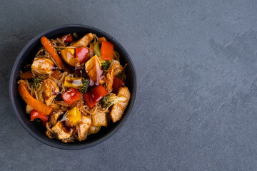 chicken yakissoba in black ceramic bowl - top view