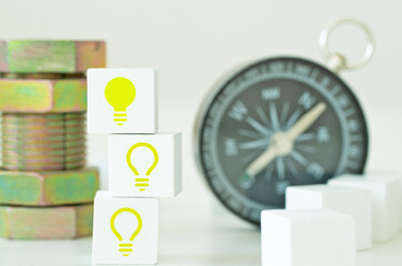 Innovation and creativity image.  Yellow shiny light bulbs on white cube