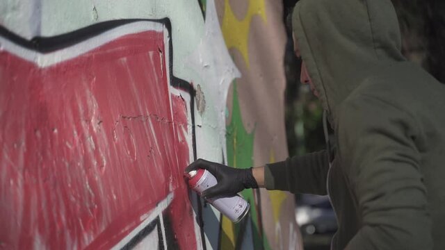 Male Graffiti Artist Painting On The Street Wall in slow motion