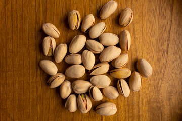 top view of many pistachios on a wooden background