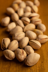 close up of many pistachios on a wooden background