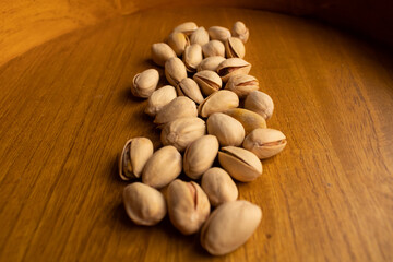 many pistachios on a wooden background