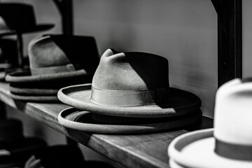 Luxury Mens hats made out of felt and wool resting on a store shelf. Black and white.