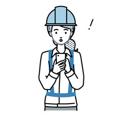 立ってスマートフォンを操作して何かに気づいて驚いた工事現場の女性
