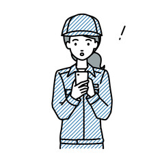立ってスマートフォンを操作して何かに気づいて驚いた作業員の女性