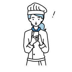 立ってスマートフォンを操作して何かに気づいて驚いた調理師の女性