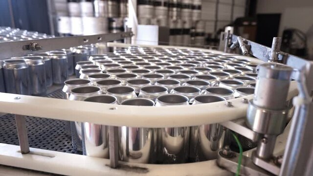 Empty aluminum cans bottleneck at conveyor belt during bottling production assembly line for filling, HD