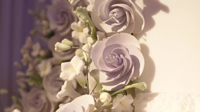 Macro close-up of lavender colored frosting rose on a floral wedding cake