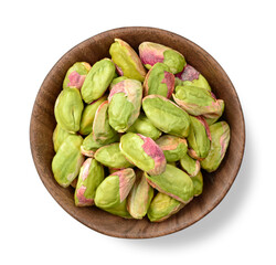 peeled pistachios in the wooden plate, isolated on the white background, top view